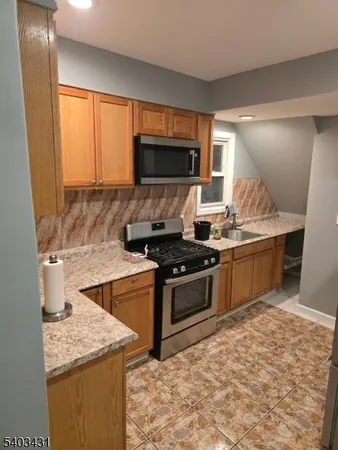 a kitchen with stainless steel appliances granite countertop a refrigerator and a stove