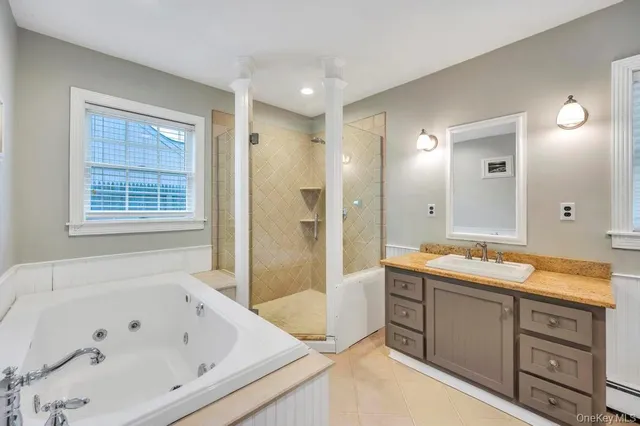 a bathroom with a tub sink double vanity granite and shower