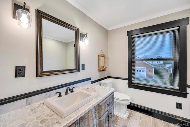 a bathroom with a sink a toilet and a mirror