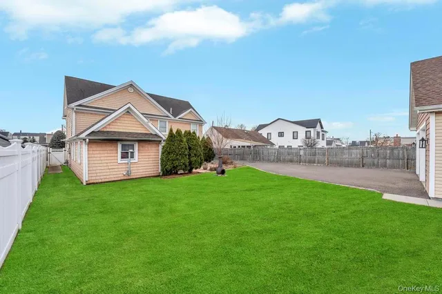 a view of a house with a big yard potted plants and large tree