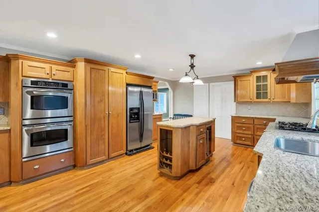 a kitchen with stainless steel appliances granite countertop a stove a sink and a refrigerator