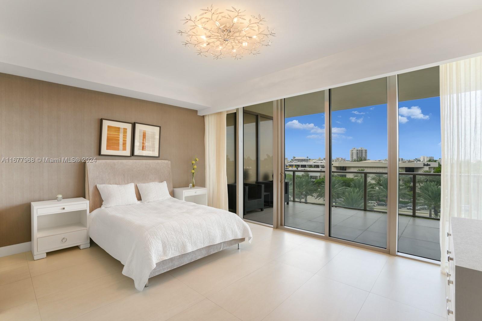 9705 Collins Avenue, Unit 501N Bal Harbour, FL 33154 - Photo 19 of 30 a spacious bedroom with a large bed and a chandelier