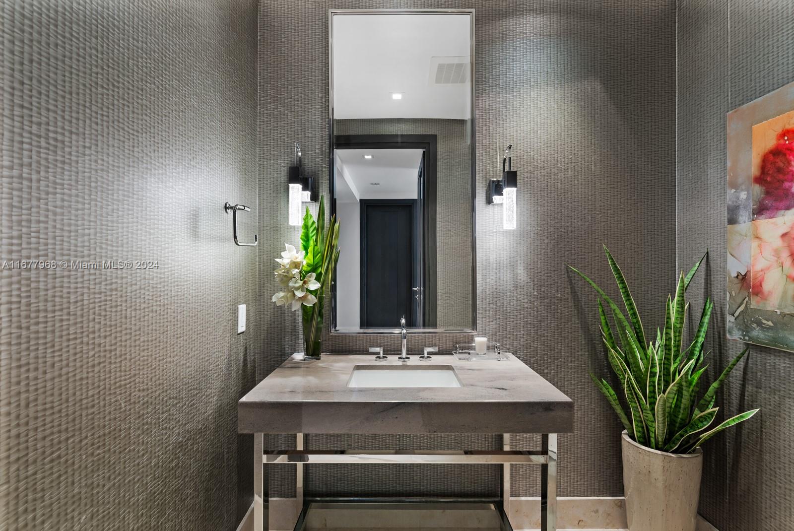 9705 Collins Avenue, Unit 501N Bal Harbour, FL 33154 - Photo 9 of 30 a bathroom with a sink a potted plant and a mirror