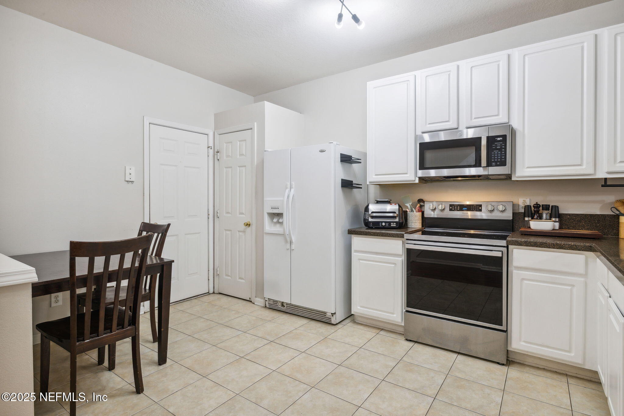 7990 Baymeadows Road East, Unit 2202 Jacksonville, FL 32256 - Photo 29 of 39 a kitchen with stainless steel appliances granite countertop a stove a microwave a sink and white cabinets