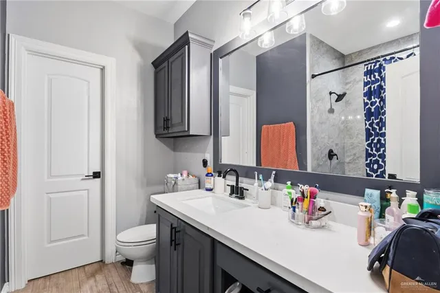 a bathroom with a granite countertop sink a toilet and a mirror