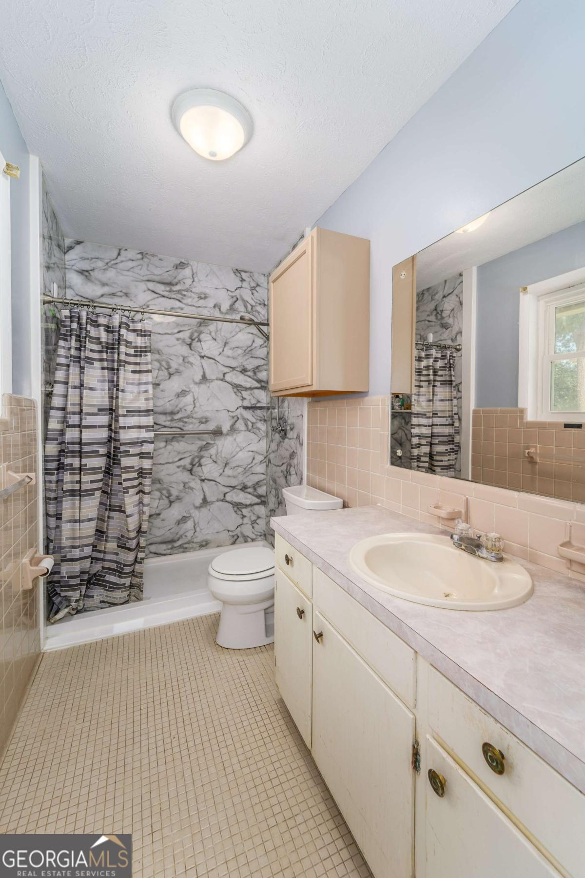 1703 Rainbow Drive Waycross, GA 31501 - Photo 13 of 19 a bathroom with a granite countertop sink toilet and shower