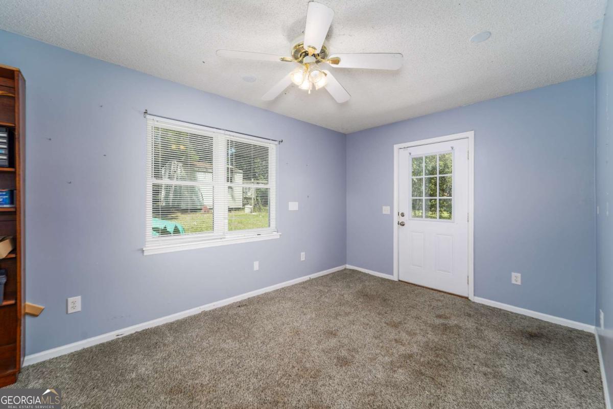1703 Rainbow Drive Waycross, GA 31501 - Photo 16 of 19 an empty room with windows and ceiling fan