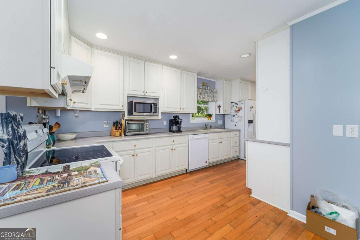1703 Rainbow Drive Waycross, GA 31501 - Photo 7 of 19 a kitchen with stainless steel appliances granite countertop a refrigerator sink and stove