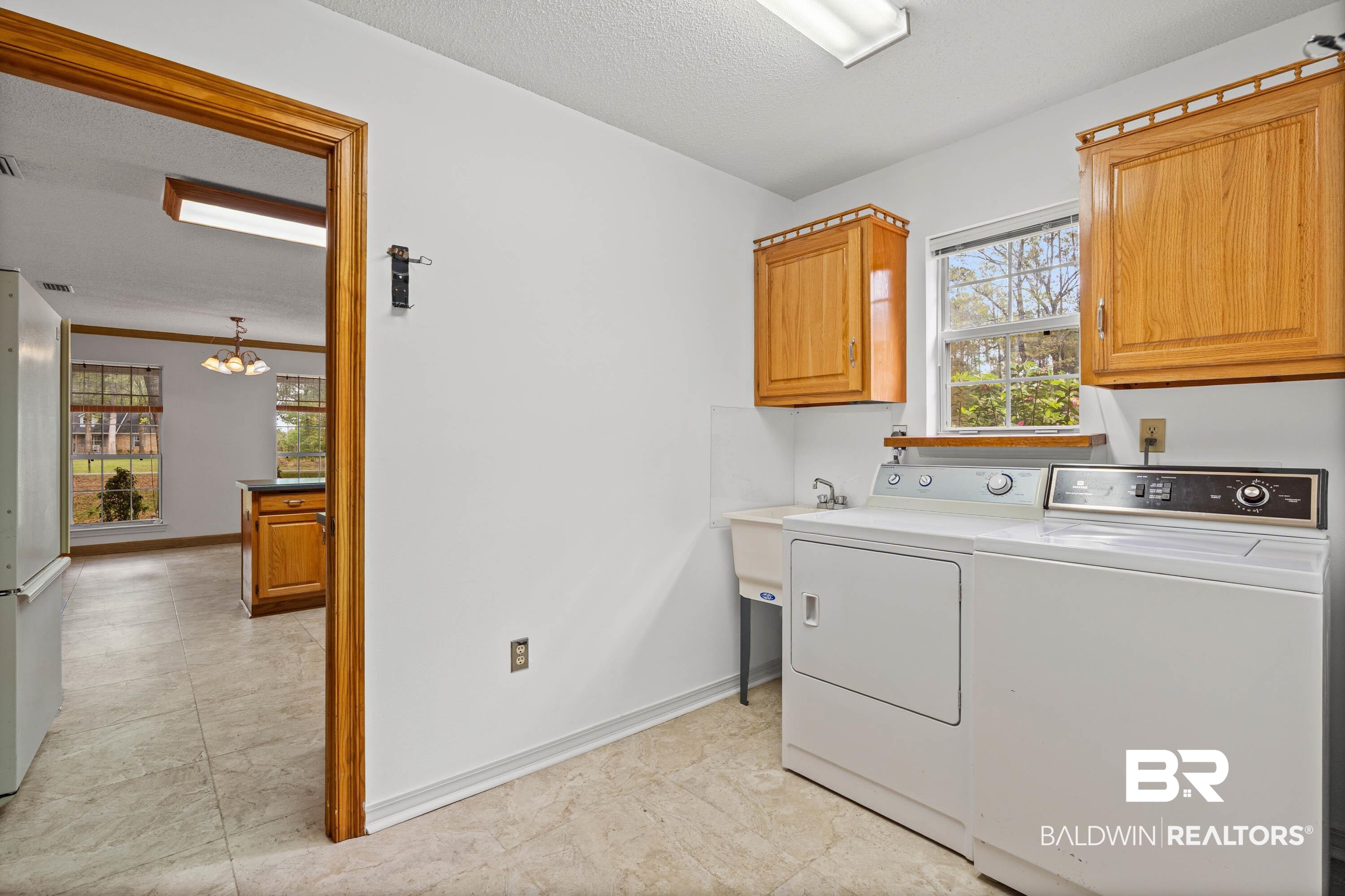 10140 Lakeview Road Bay Minette, AL 36507 - Photo 22 of 35 Laundry area with a textured ceiling, washing machine and clothes dryer, and cabinet space