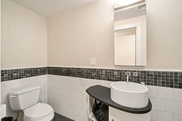 a bathroom with a sink a toilet and a mirror