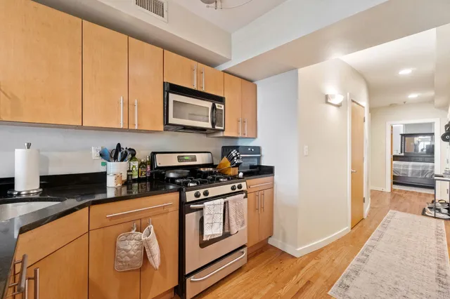 a kitchen with stainless steel appliances granite countertop a stove a sink and a refrigerator
