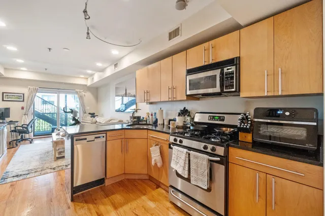 a kitchen with stainless steel appliances granite countertop a stove a sink and a microwave
