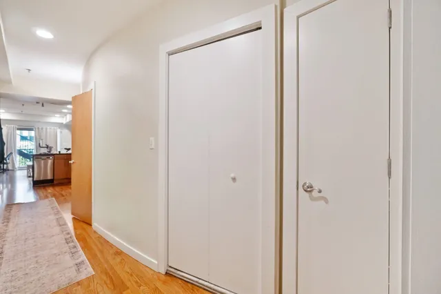 a view of a hallway with bathroom and wooden floor