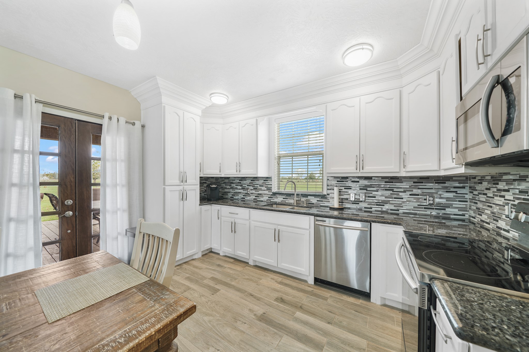 10507 Padon Road Needville, TX 77461 - Photo 27 of 48 a kitchen with stainless steel appliances granite countertop a stove a sink and a refrigerator