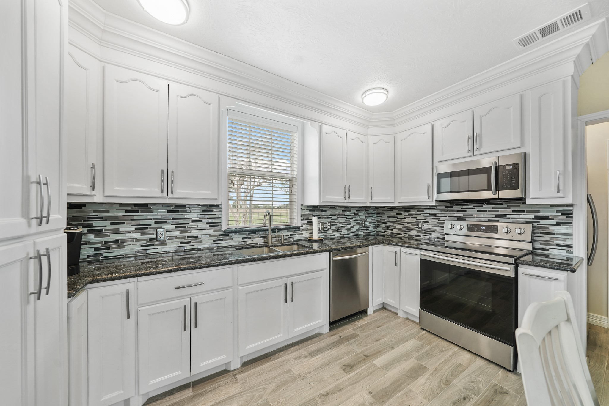 10507 Padon Road Needville, TX 77461 - Photo 28 of 48 a kitchen with stainless steel appliances granite countertop a stove a sink and a microwave