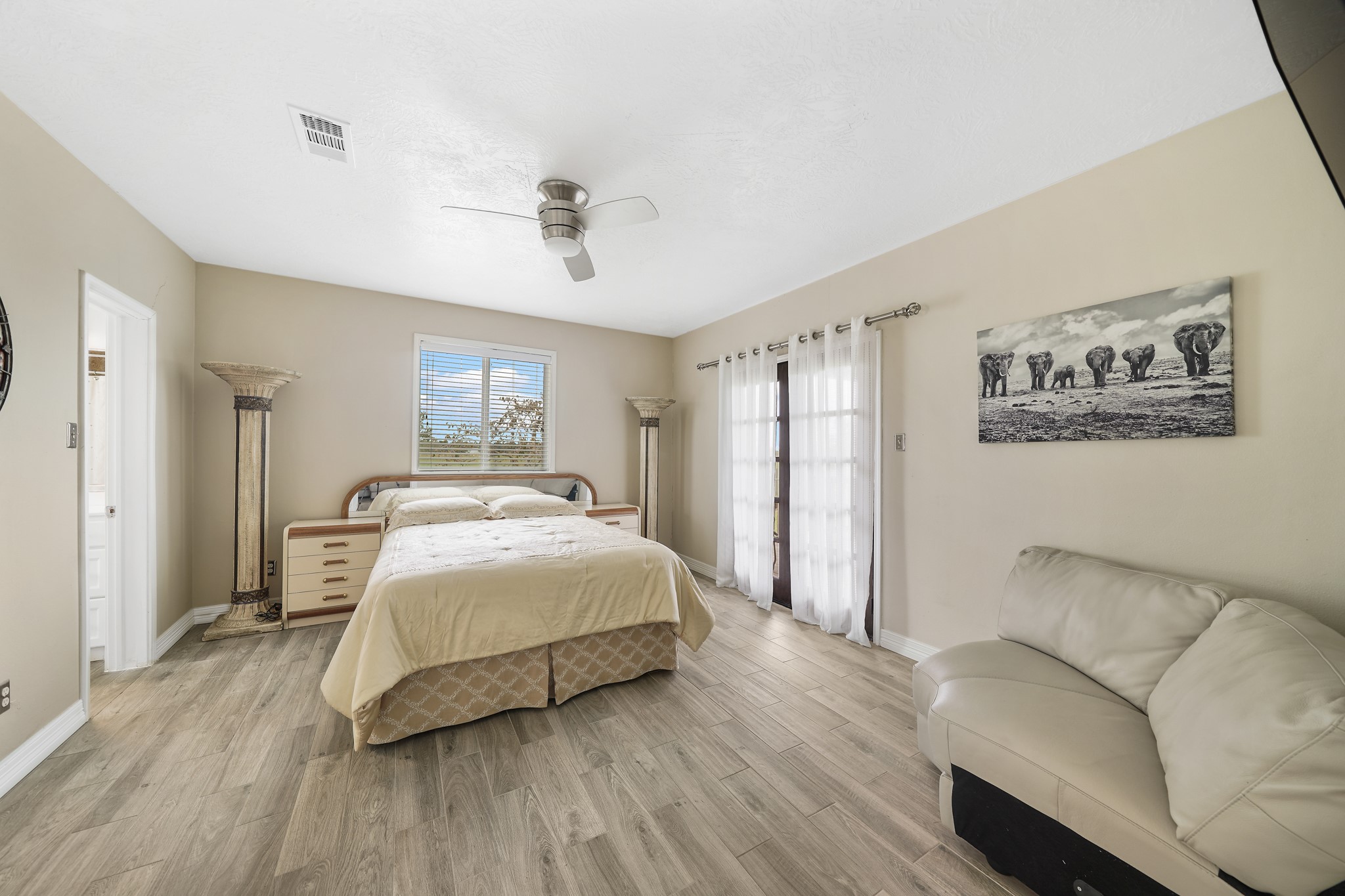 10507 Padon Road Needville, TX 77461 - Photo 31 of 48 a spacious bedroom with a bed and a chandelier