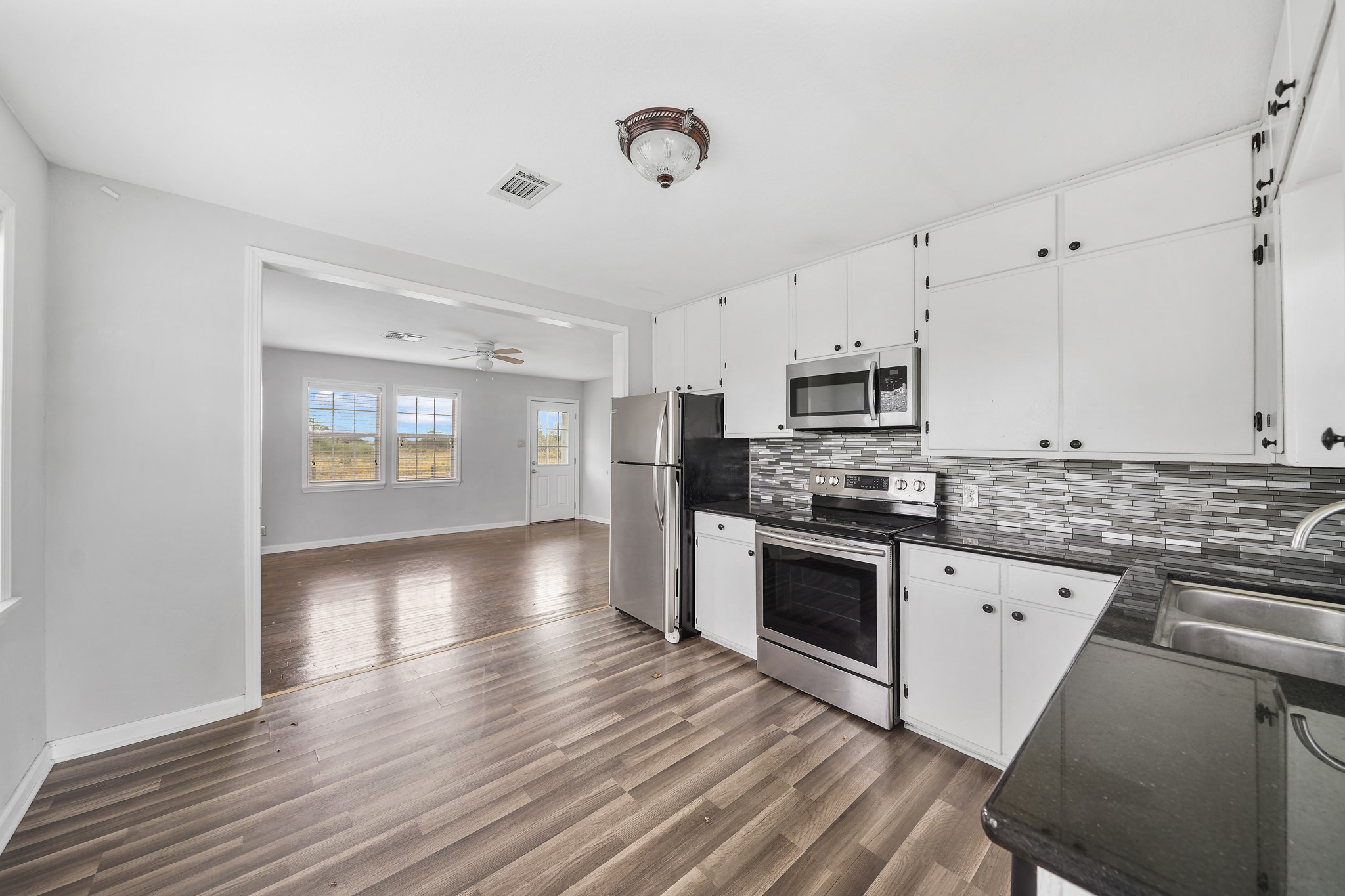 10507 Padon Road Needville, TX 77461 - Photo 44 of 48 a kitchen with stainless steel appliances granite countertop a stove cabinets and wooden floor