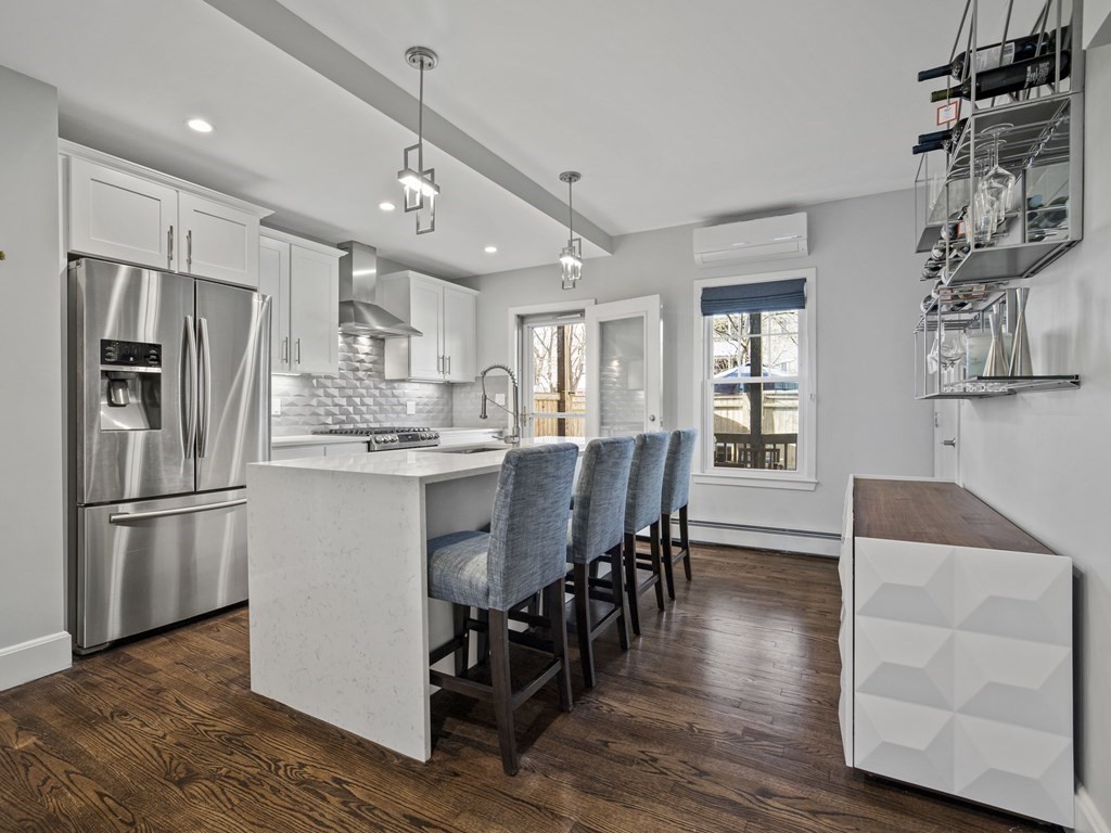 a kitchen with stainless steel appliances refrigerator dining table and chairs