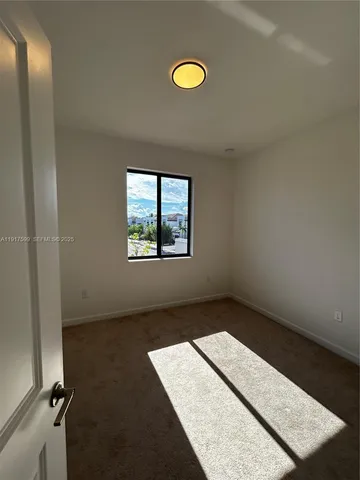 an empty room with windows and mirror