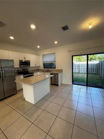 a large kitchen with a large counter top stainless steel appliances and cabinets