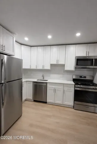 a kitchen with stainless steel appliances granite countertop a refrigerator sink and stove
