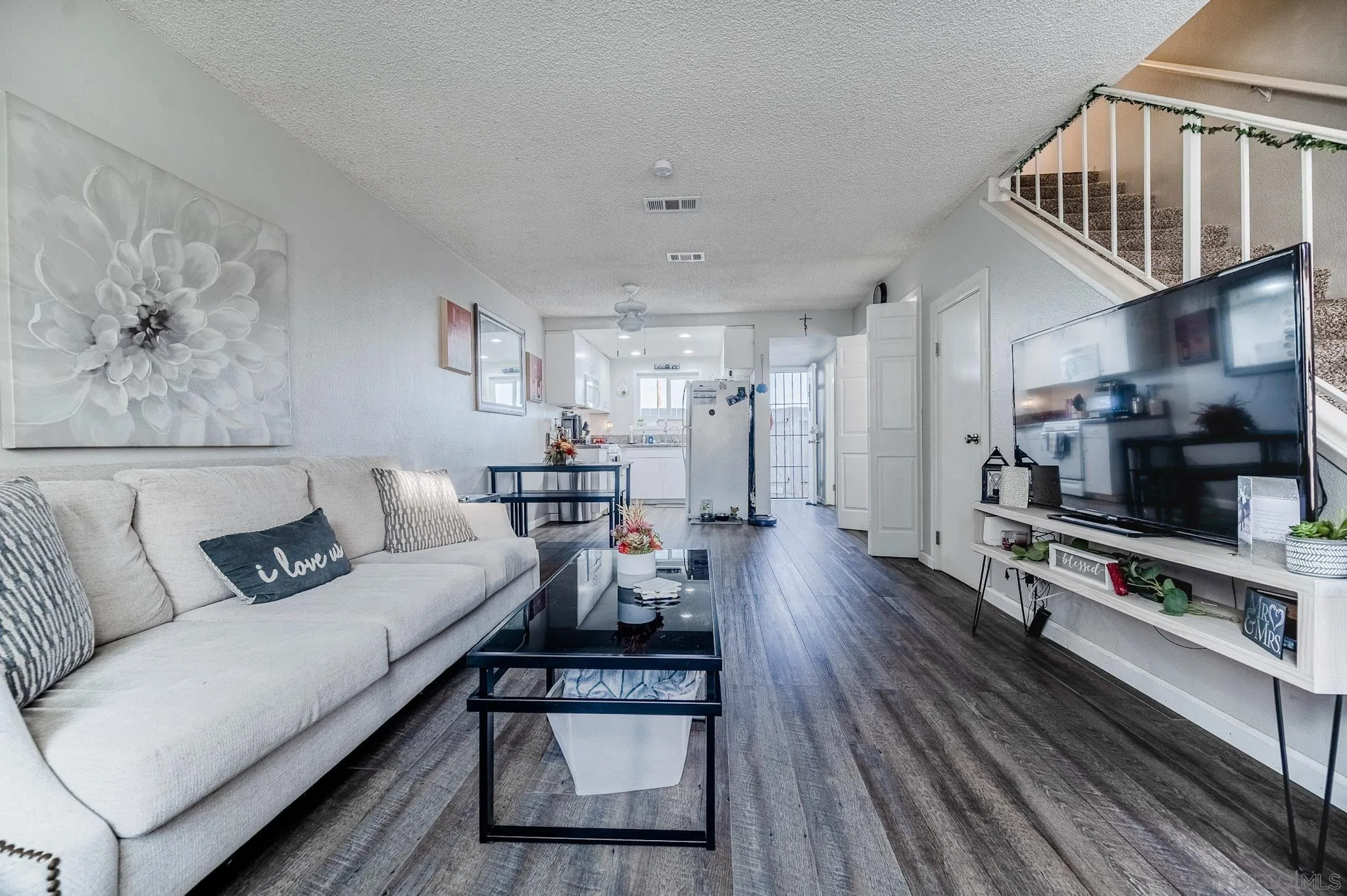 5140 North River Road, Unit F Oceanside, CA 92057 - Photo 1 of 39 a living room with furniture and a flat screen tv