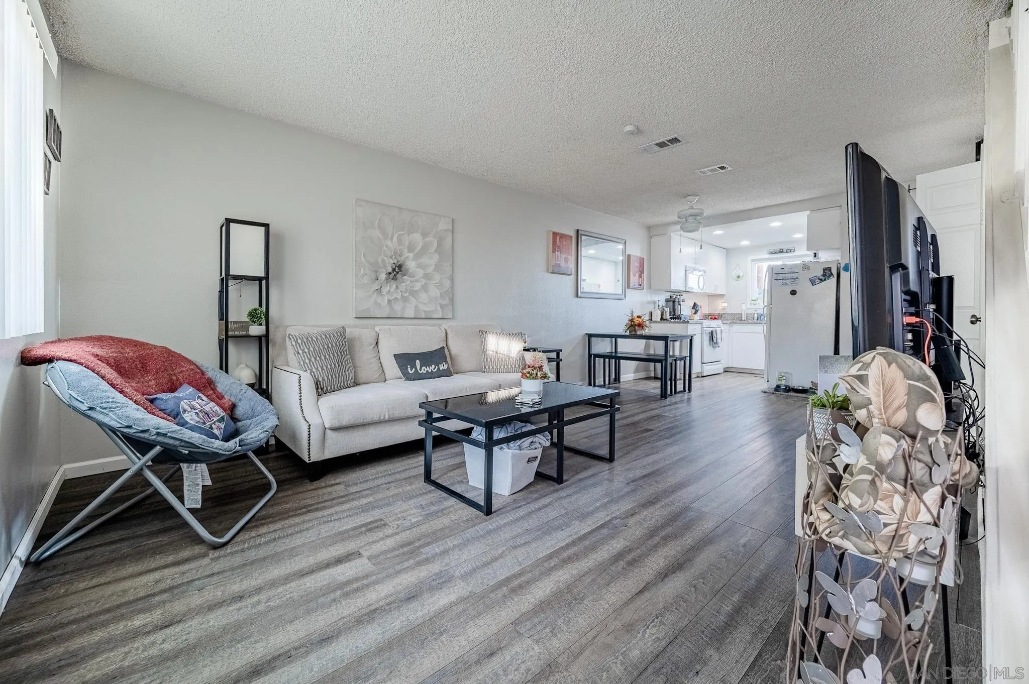 5140 North River Road, Unit F Oceanside, CA 92057 - Photo 4 of 39 a living room with furniture a flat screen tv and a wooden floor