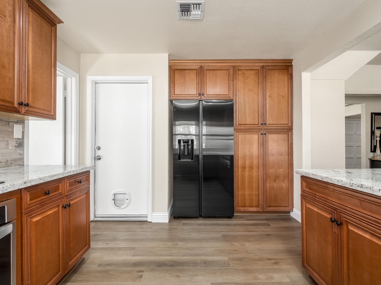 16181 Monreal Road Madera, CA 93636 - Photo 14 of 40 a kitchen with granite countertop a refrigerator and a sink