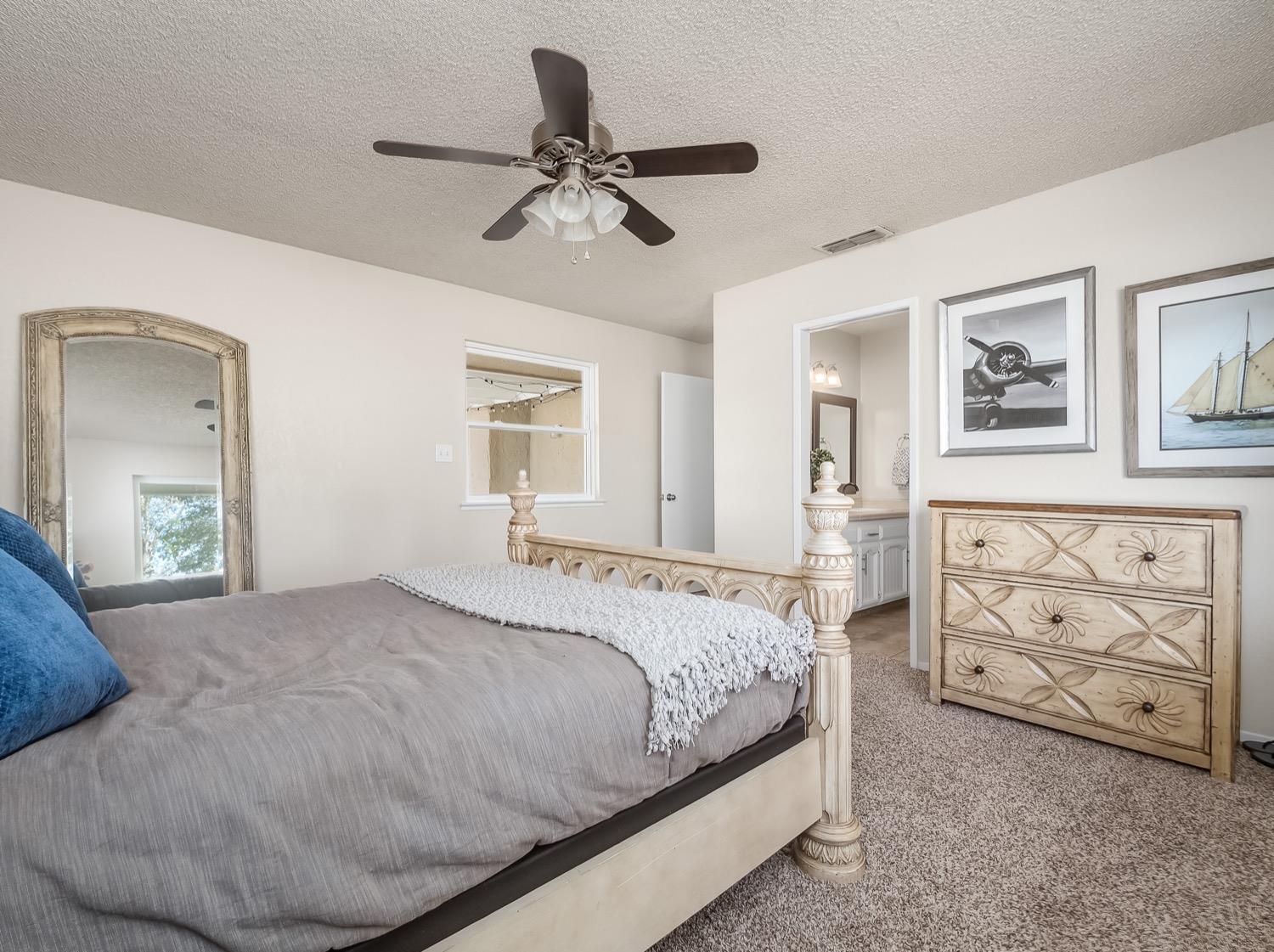 16181 Monreal Road Madera, CA 93636 - Photo 22 of 40 a bedroom with a bed and a chandelier