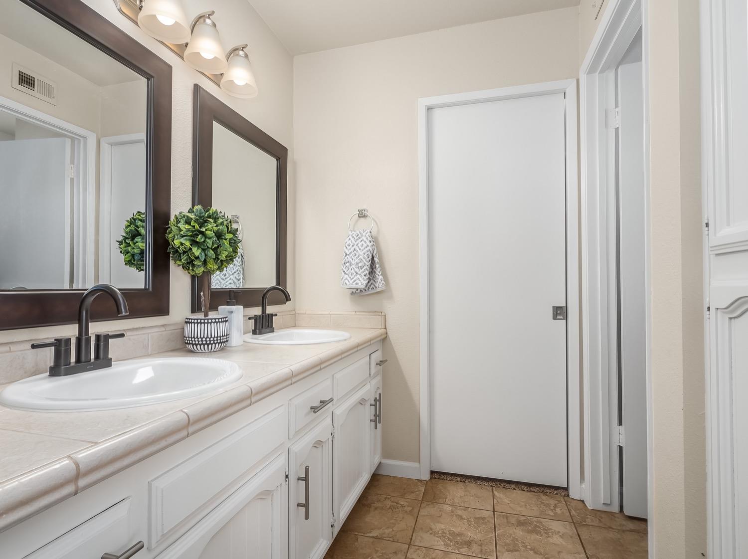 16181 Monreal Road Madera, CA 93636 - Photo 23 of 40 a bathroom with a double vanity sink and a mirror