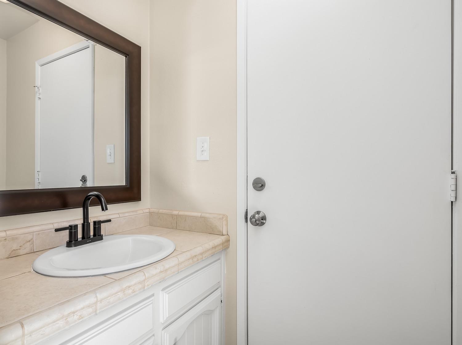 16181 Monreal Road Madera, CA 93636 - Photo 28 of 40 a bathroom with a sink and a mirror