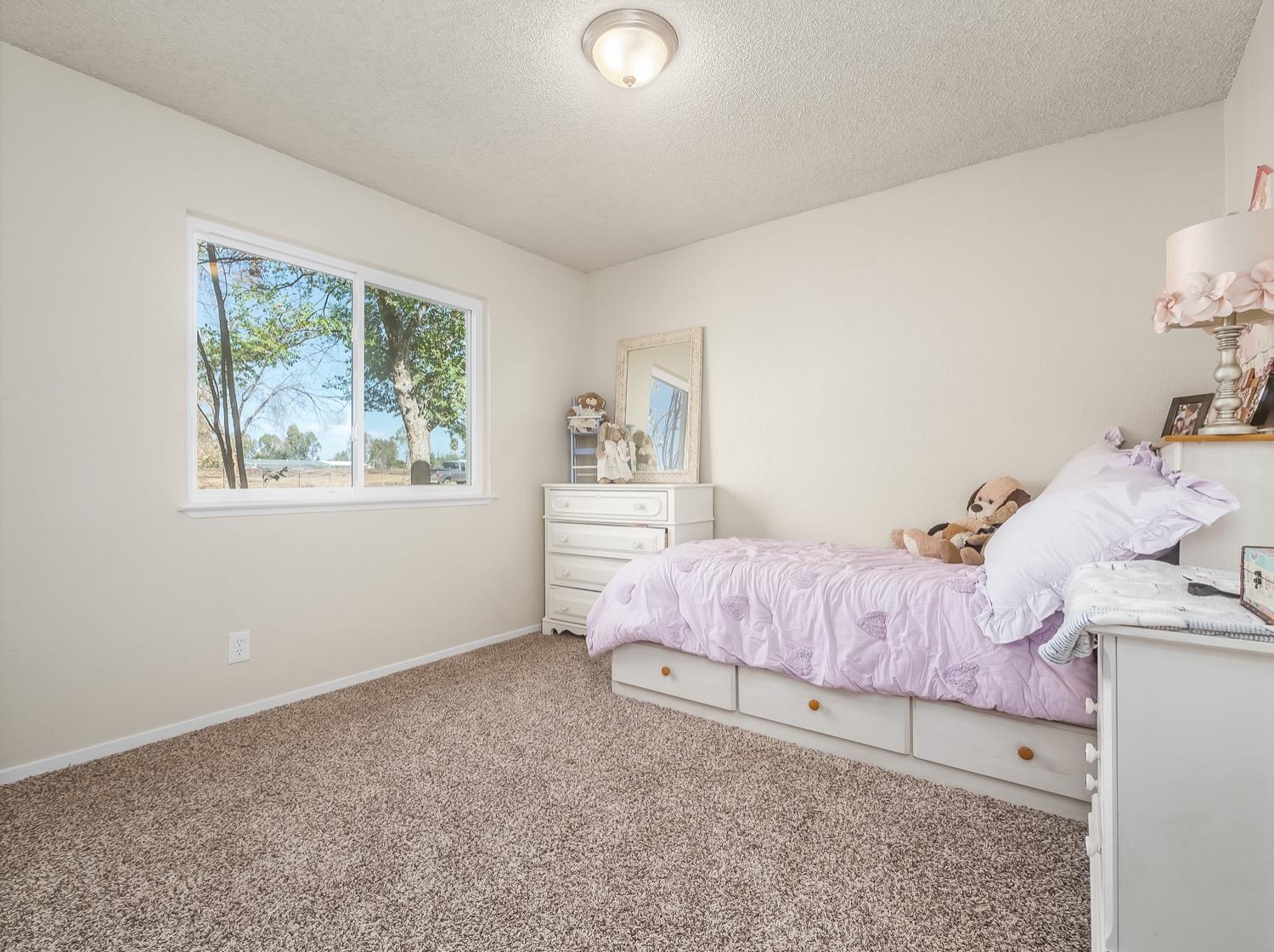 16181 Monreal Road Madera, CA 93636 - Photo 29 of 40 a bedroom with a bed and a window