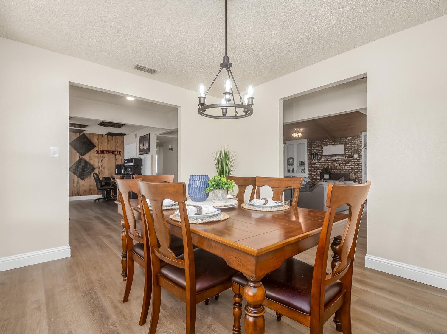16181 Monreal Road Madera, CA 93636 - Photo 6 of 40 a view of a dining room with furniture wooden floor and chandelier
