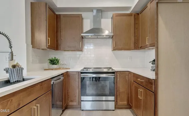 a kitchen with stainless steel appliances granite countertop a stove and a sink