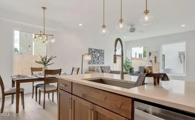 a kitchen with kitchen island granite countertop a sink a counter top space and living room view
