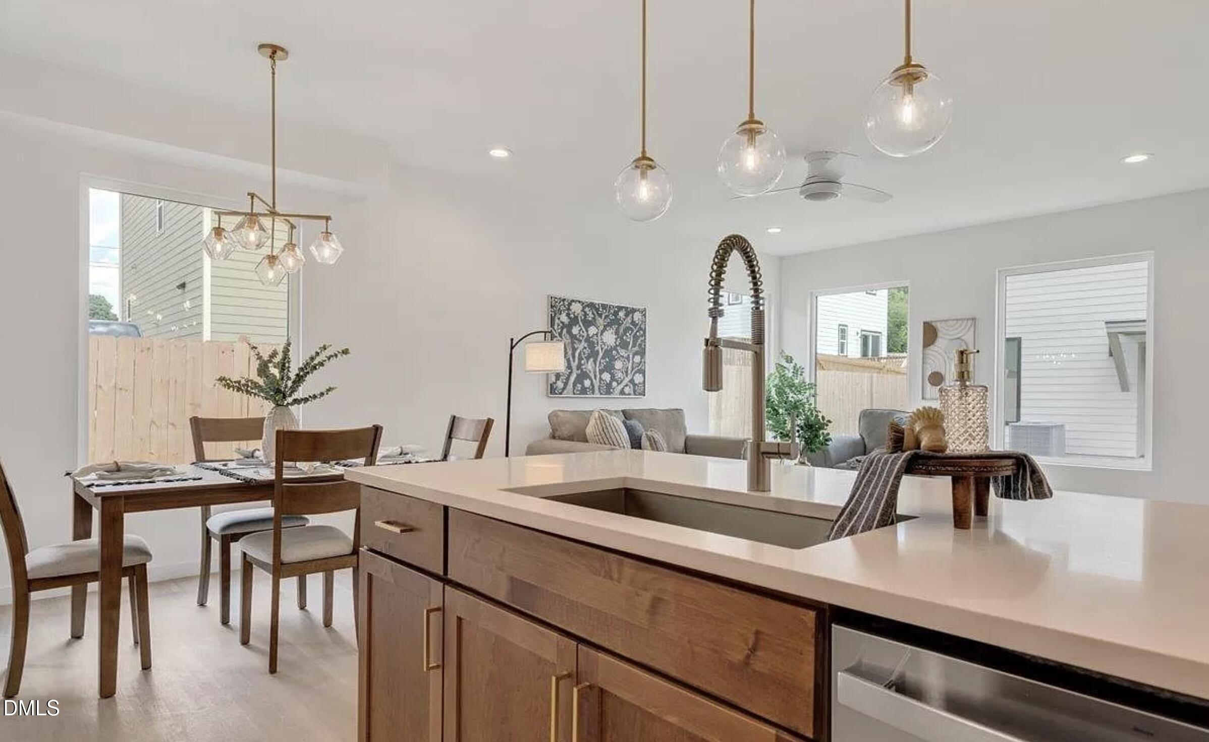 502 A Commonwealth Street Durham, NC 27703 - Photo 13 of 30 a kitchen with kitchen island granite countertop a sink a counter top space and living room view