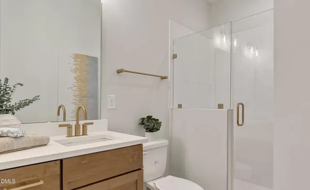 a bathroom with a sink vanity granite toilet and shower