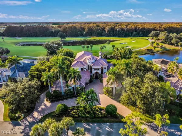 an aerial view of a houses with a garden and lake view