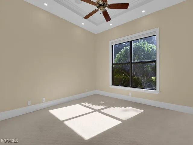 an empty room with a window and a ceiling fan