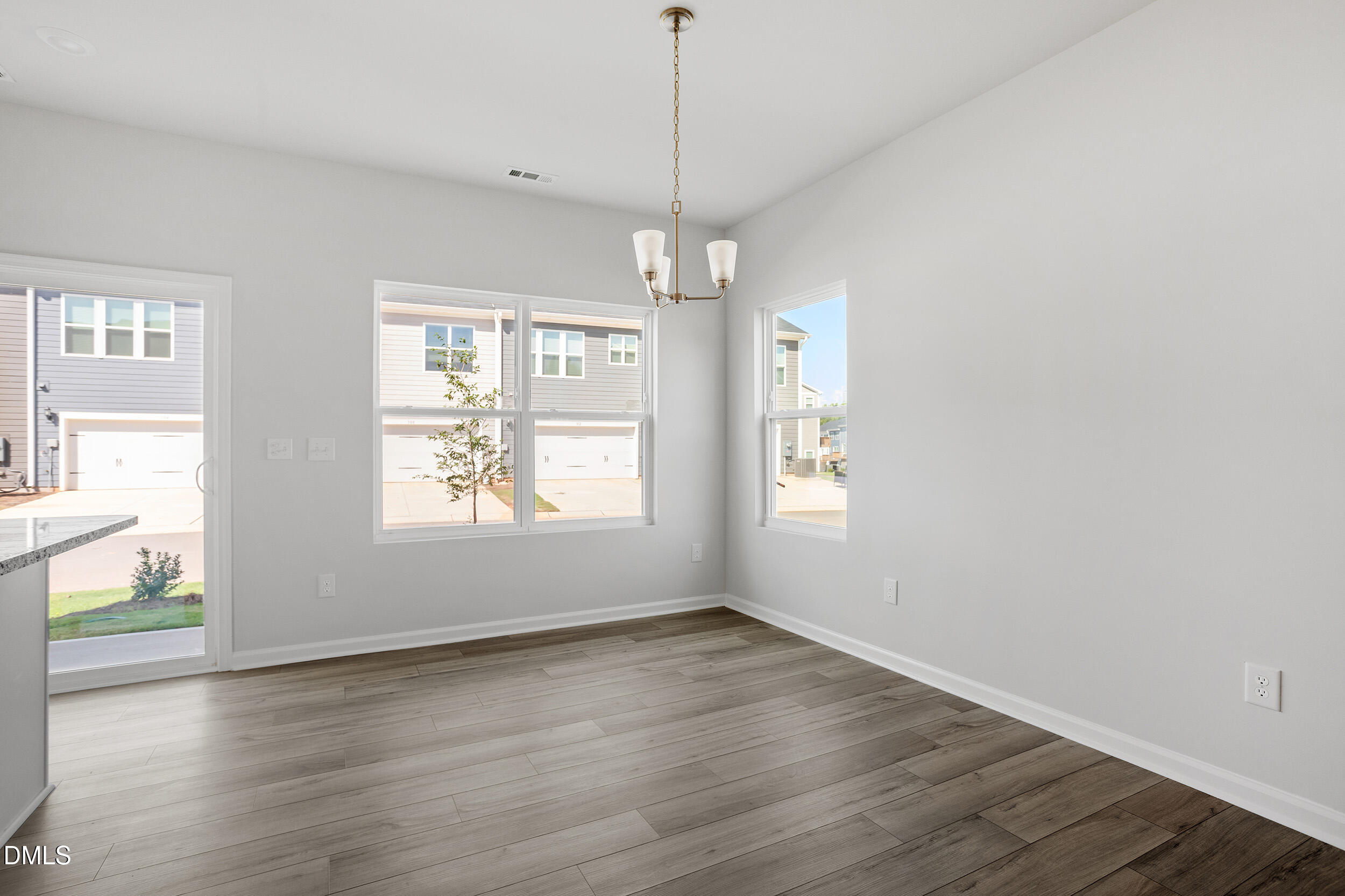 191 Powell Townes Way, Unit 319 Raleigh, NC 27603 - Photo 12 of 50 an empty room with wooden floor and windows