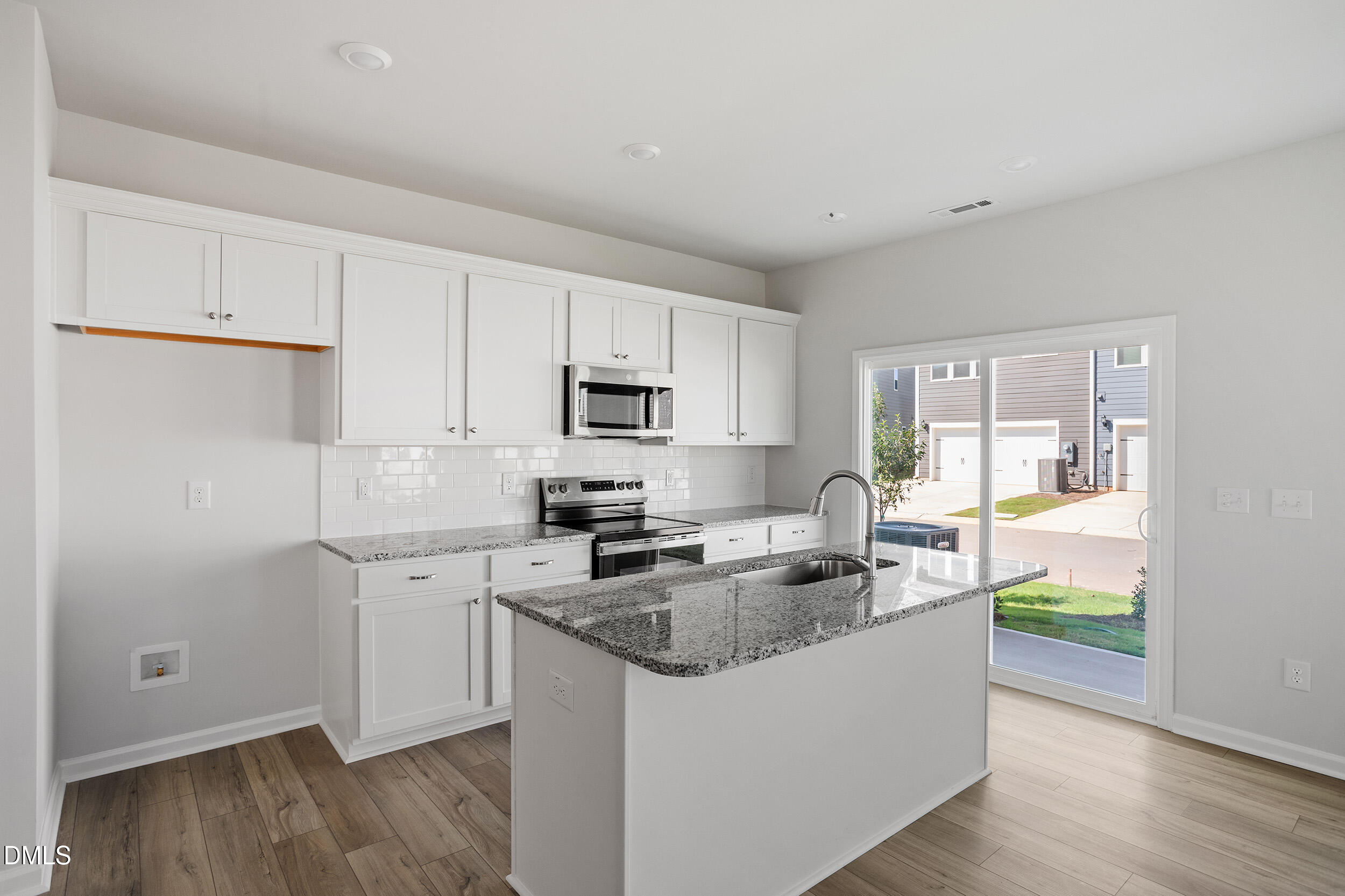 191 Powell Townes Way, Unit 319 Raleigh, NC 27603 - Photo 13 of 50 a kitchen with granite countertop a sink a counter top space and cabinets