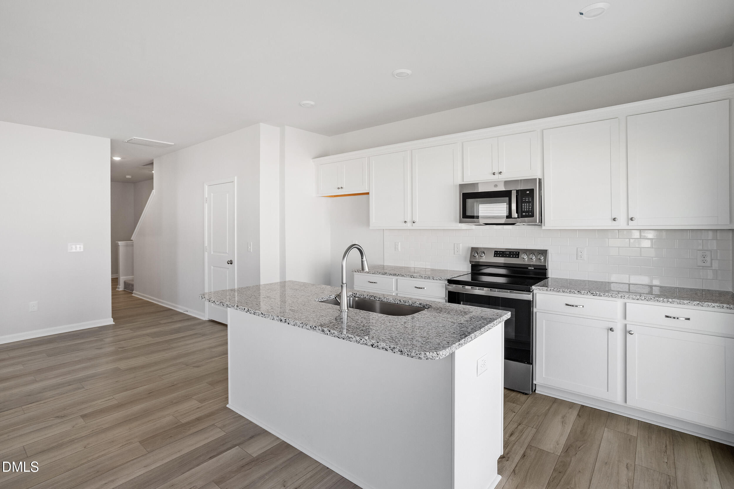 191 Powell Townes Way, Unit 319 Raleigh, NC 27603 - Photo 15 of 50 a kitchen with granite countertop a sink and a stove top oven