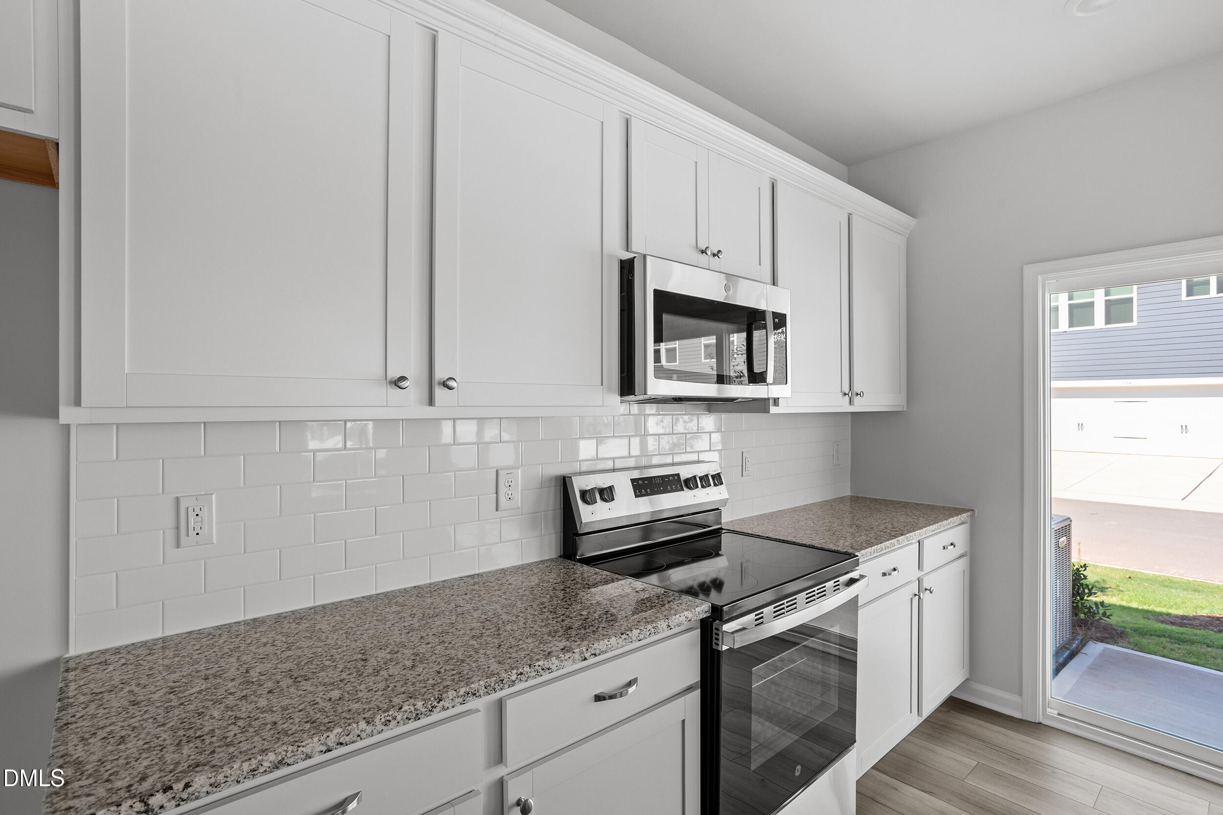 191 Powell Townes Way, Unit 319 Raleigh, NC 27603 - Photo 17 of 50 a kitchen with granite countertop white cabinets and white appliances