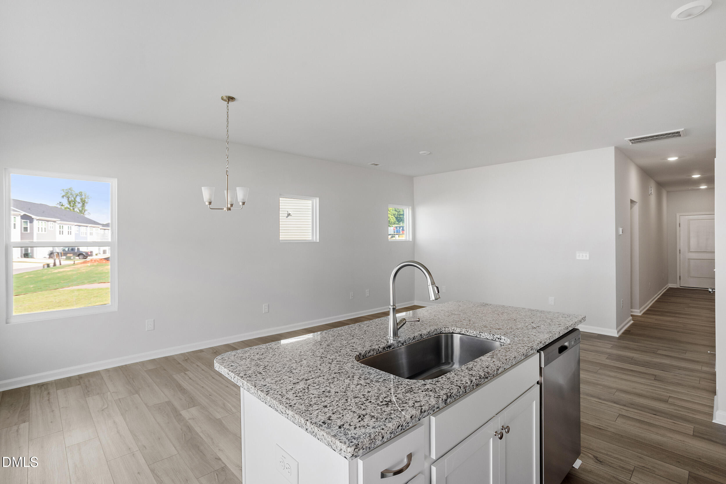191 Powell Townes Way, Unit 319 Raleigh, NC 27603 - Photo 18 of 50 a kitchen with granite countertop a sink and a wooden floor