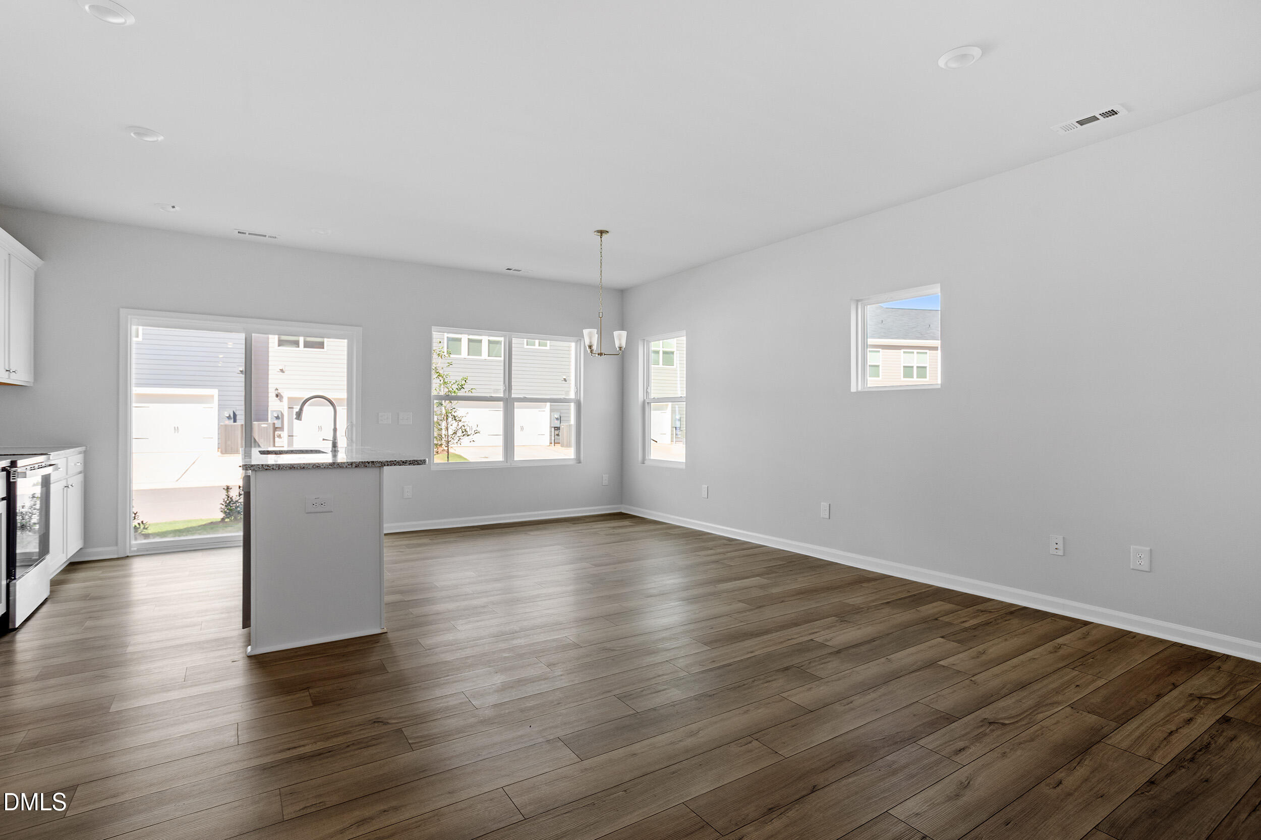 191 Powell Townes Way, Unit 319 Raleigh, NC 27603 - Photo 6 of 50 an empty room with wooden floor and windows