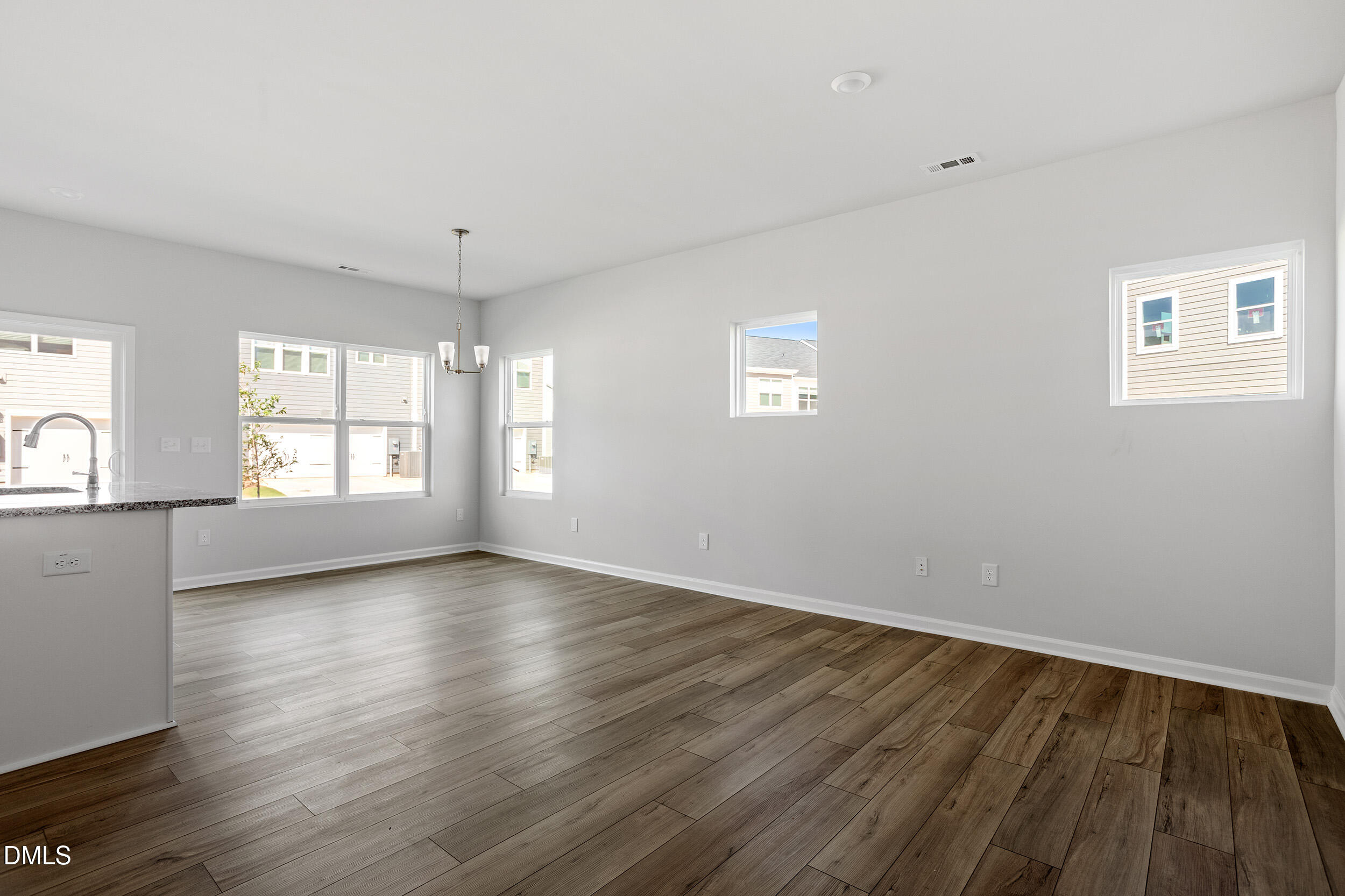 191 Powell Townes Way, Unit 319 Raleigh, NC 27603 - Photo 7 of 50 an empty room with wooden floor and windows