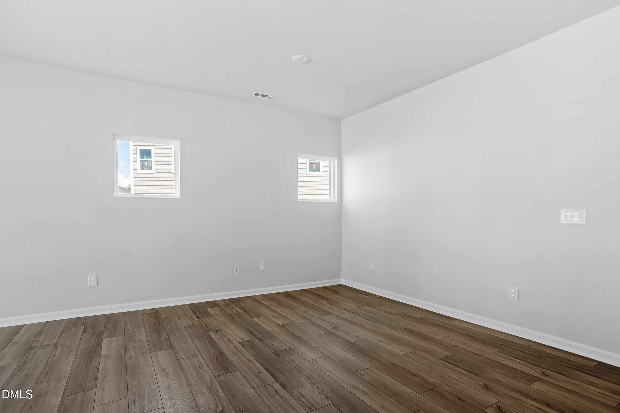 191 Powell Townes Way, Unit 319 Raleigh, NC 27603 - Photo 8 of 50 a view of an empty room with wooden floor and a window