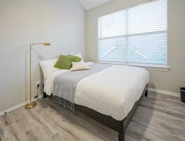 a bed sitting in a bedroom next to a window
