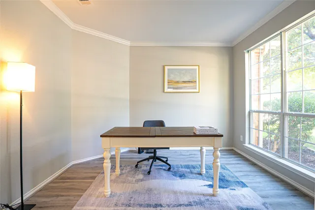a view of a workspace with furniture and a window