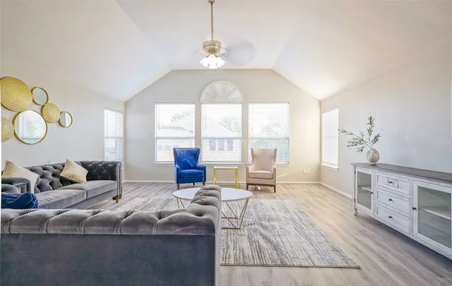 a living room with furniture chandelier and a large window